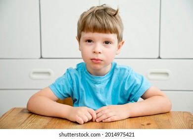 Back To School. Kid Sits By The Table In Nursery Or Kindergarten.  Emotions. Face Expression. Sad Boy Listening.
 