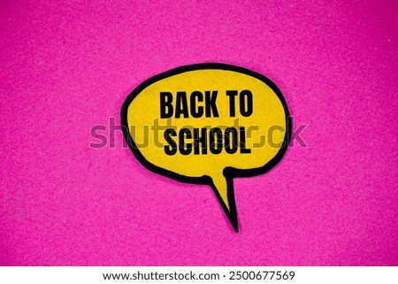 Back to school message written on yellow paper speech bubble with pink background. Conceptual back to school symbol. Copy space.