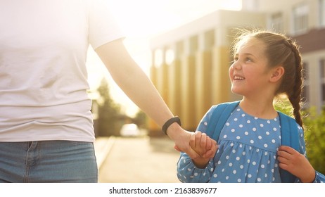 back to school. mom and sun daughter a go hand in hand to school for lesson. education training support concept. child walk to school with a backpack. daughter and mom rush to school. family day