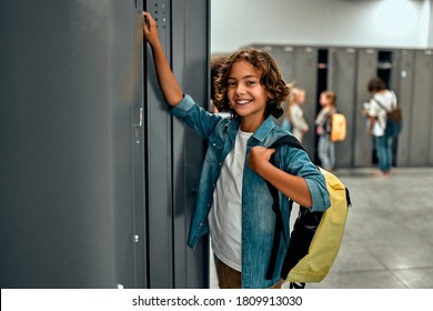 Back to school. Multiracial pupils of primary school in dressing room near personal lockers. Children are ready to study - Powered by Shutterstock