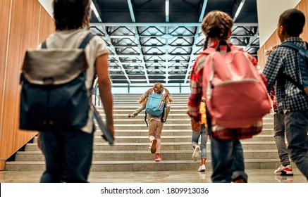 Back to school. Multiracial pupils of primary school in school hall on stairs. Children are ready to study - Powered by Shutterstock