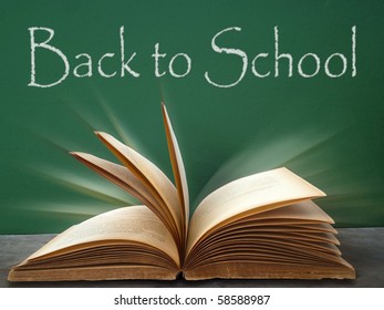 back to school on green board and book on table - Shutterstock ID 58588987