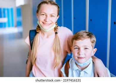 Back To School. Portrait Of Little Brother And Teenager Sister, Girl And Boy In Protective Masks With School Backpacks Go To Study After A Pandemic, Quarantine Or Coronavirus. First School Day.