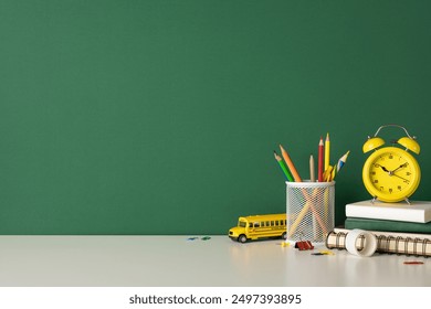 Back to school scene with school supplies including pencils, a toy school bus, clock, and books on a desk - Powered by Shutterstock