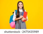 Back to school. Schoolgirl student hold book on yellow isolated studio background. School and education concept. Teenager girl in school uniform.