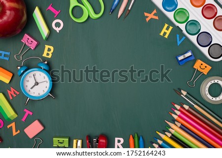 Back to school shopping concept. Top above overhead view photo of colorful stationery and an apple isolated on greenboard