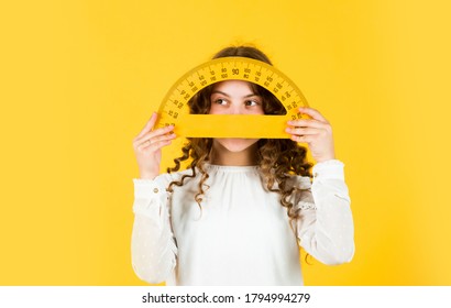 Back to school. Student learning geometry yellow background. Measure angles in degrees. School lessons. Adorable cute pupil. She loves studying. Small girl holding protractor for geometry lesson.