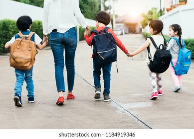 Back to school students mother group going school together. Parent send little boy and girl for first class semester term with schoolbag or satchel together. Collaborative learning and empathy daycare