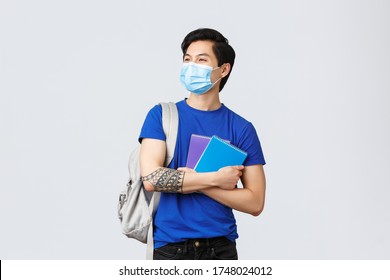 Back To School, Studying During Covid-19, Education And University Life Concept. Carefree Handsome Asian Male Student, College Freshman In Medical Mask With Notebooks And Backpack