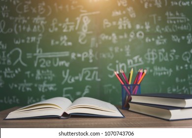 Back to school supplies. Books and blackboard on wooden background - Shutterstock ID 1070743706