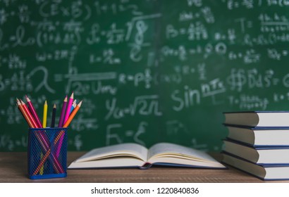 Back to school supplies. Books and blackboard on wooden background. - Shutterstock ID 1220840836
