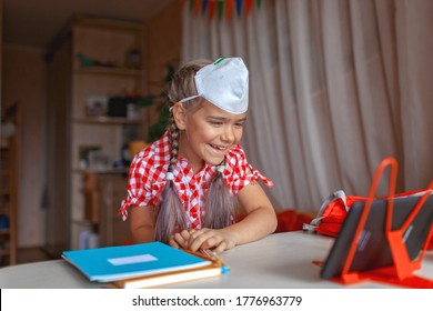 Back To School, Supply List. Cute Schoolgirl With Tablet Showing To Online Friend Her New School Equipment And Discussing New School Dress Code, Face Mask. Social Distance Learning And New Guidance