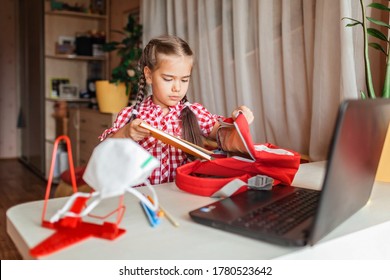 Back To School, Supply List. Cute Schoolgirl Showing To Online Friend Her New School Equipment And Discussing New School Dress Code, Face Mask. Social Distance Learning And New Guidance