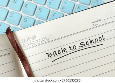 Back to school text on notebook with keyboard representing seasonal education, learning preparation and academic concept.