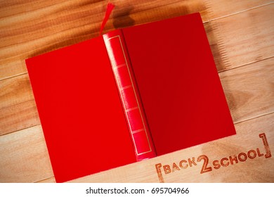 Back to school text over white background against open book upside down on table - Powered by Shutterstock