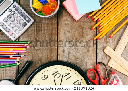 Back to school. School tools around. Vertically. A wooden background.
