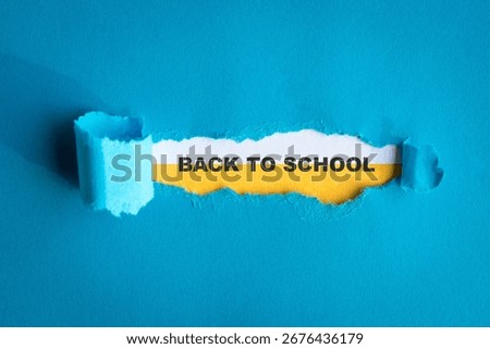Back to school, typescript text on white yellow paper with torn blue paper.