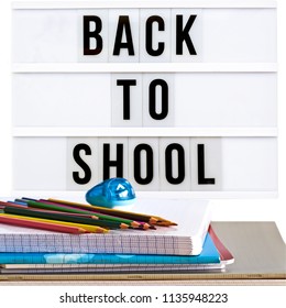 Back to school written in a light box with school supplies