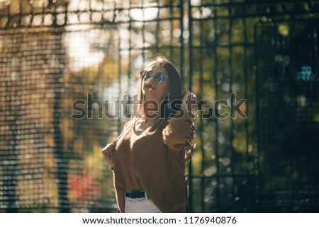 Similar – Kühle blonde Frau mit Sonnenbrille und schwarzem Kleid, die sich bei Sonnenuntergang in der Natur amüsiert.