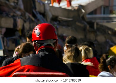 The Back of the search and rescue worker in front of blurred building destroyed in the earthquake,watching and resting