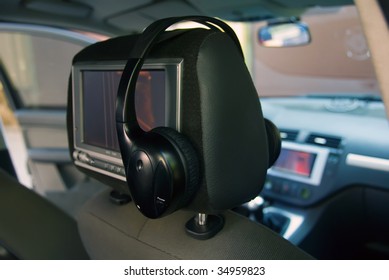 In The Back Seat Of A Car Mounted The Screen To View Video And Attached Headphones