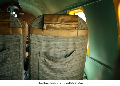  Back Of Seat On An Abandoned Airplane. Natural Light Coming In Plane Window. Dark Vignetting.                               