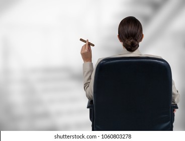 Back of seated business woman smoking cigar against blurry grey stairs - Powered by Shutterstock