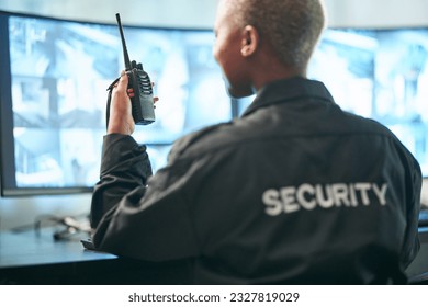 Back, security and radio surveillance with a woman officer in a control to monitor criminal activity. Safety, dispatch and cctv with a female guard sitting in her office using a walkie talkie - Powered by Shutterstock