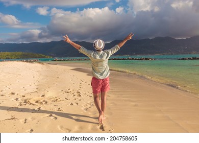 Back Of A Sexy Young Man Walking On The Beach And Celebrates His Joyous Life