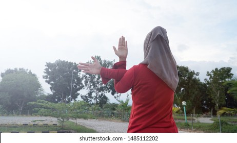 Back Shoot Hijab Woman Stretching Her Arms. Female Doing Warmup Stretching Workout On Outdoor City Park
