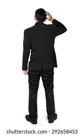 Back Shot Of Clueless Man In Business Suit Scratching His Head, Full Body Isolated On White Background