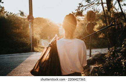 Back Shot Image Woman Holding A Trash Bag And A Garbage Collector While Cleaning The Forest.