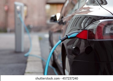 Back side of the car loading energy. Detail of the power supplier for charging of an electric car. - Shutterstock ID 457237240