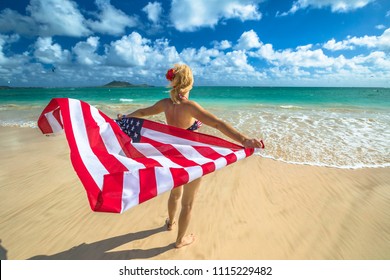 Back side Hawaiian woman holding a waving American flag in American flagged bikini. Tropical Lanikai Beach, east shore of Oahu in Hawaii, USA. Freedom and 4th July patriotic concept. - Powered by Shutterstock