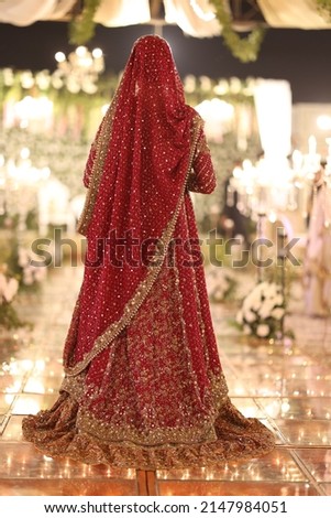 Back side of an Indian  Pakistani Bride wearing Red Dress Lehenga