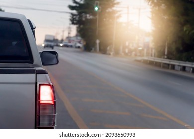 Back Side Of Pick Up Car Gray Color On The Asphalt Road. With Traffic Conditions And Hot Sun During The Day And Other Cars Driving Opposite Lens.