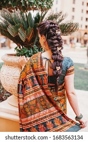 Back Side Portrait Of Indian Woman Wearing Saree And Beautiful Braided Hairdo On Her Long Hair