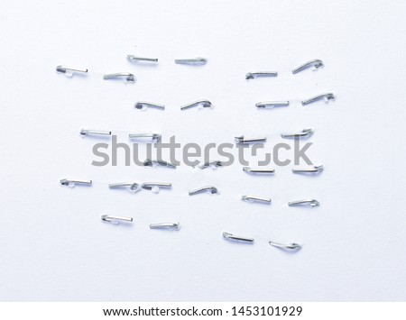 Back side staples pushed into a piece of white paper. Isolated on white background.