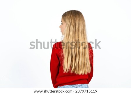 The back side view of a Beautiful girl wearing red knitted sweater. Studio Shoot.