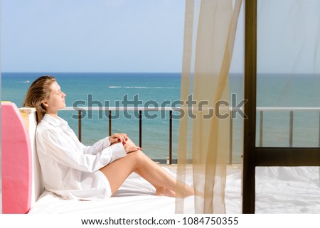 Back side view of cheerful beautiful woman enjoying healthy relax lifestyle looking out window having positive day and bright sunny oceanfront outdoors background. Travel relaxation destination