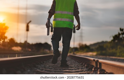 Back side view engineer under inspection and checking construction process railway switch and checking work on railroad station .Engineer wearing safety uniform and safety helmet in work.