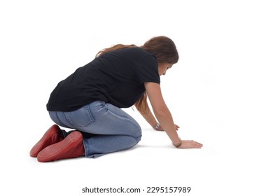 back and side view a young girl who is on her knees on the floor looking for something on a white background