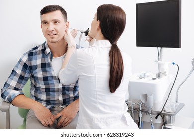 Back Side Of Young Female Doctor Touching Male Ear