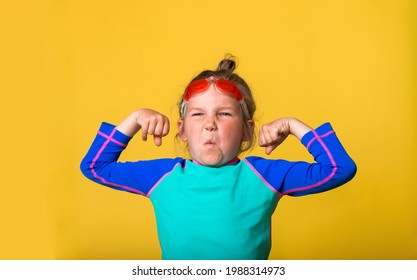 Back To Sport School. Strong Proud Little Child Shows Muscles. Funny Nerd Kid Make Emotional Grimace. Geek Sportish Child Isolated On Yellow. Education And Creativity Concept.