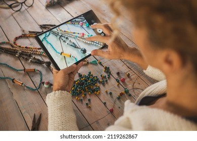 Back Top View Of Woman Taking Picture With Tablet At Beads Necklace Hand Made On The Table. Concept Of Modern Online Store Job Work Concept People