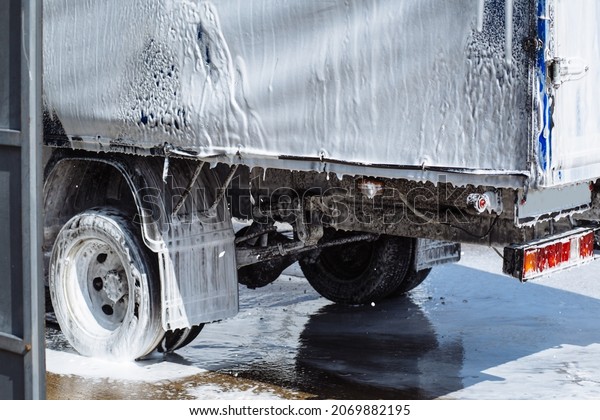 Back of truck transport in white foam at car\
wash. Car wash self service hand\
wash