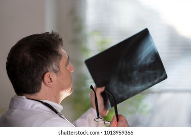 Back Turned Concentrated Radiologist Reading X-ray Images