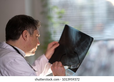 Back Turned Concentrated Radiologist Reading X-ray Images