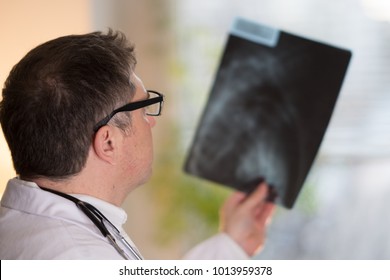 Back Turned Concentrated Radiologist Reading X-ray Images