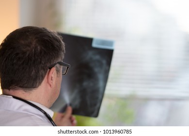 Back Turned Concentrated Radiologist Reading X-ray Images